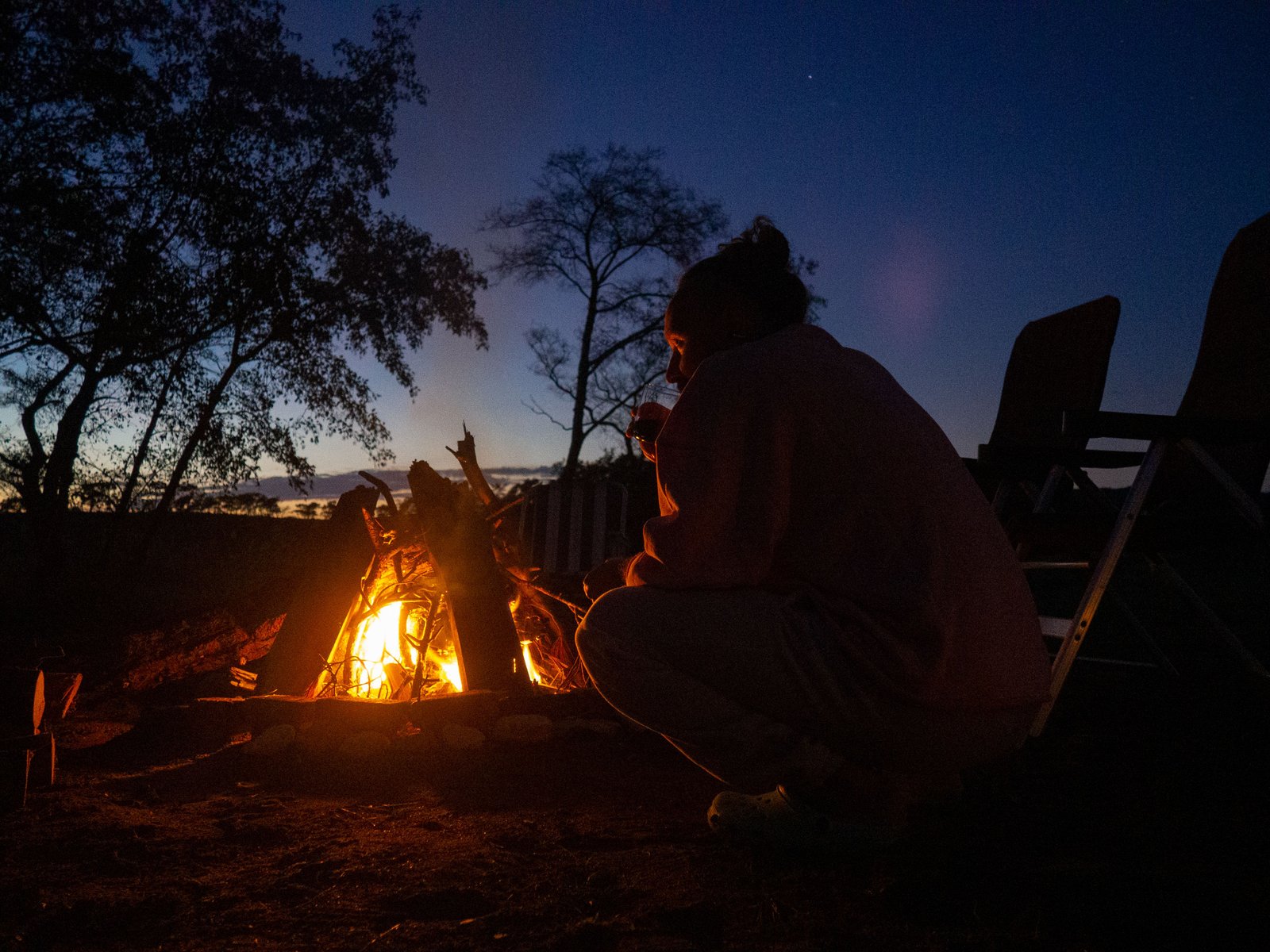 A person sitting close to a campfire